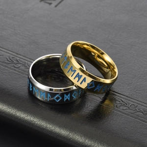 Macro shot of Viking rune rings in gold and silver with glowing blue engravings