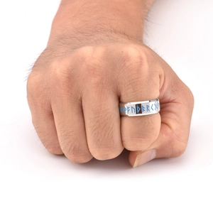 Macro detail of men's stainless steel ring featuring blue Viking Runic letter engravings