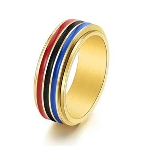 Detailed macro view of 18K gold spinner ring with three color enamel bands on white background