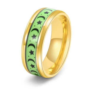 Macro shot of titanium steel ring featuring glowing green inlay with moon and star patterns