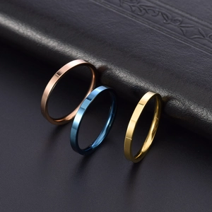 Close-up of 2mm minimalist stainless steel rings in rose gold, blue, and gold finishes