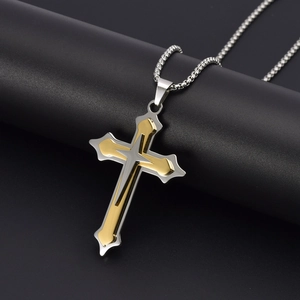 Detailed close-up of double-layered silver and gold stainless steel cross necklace