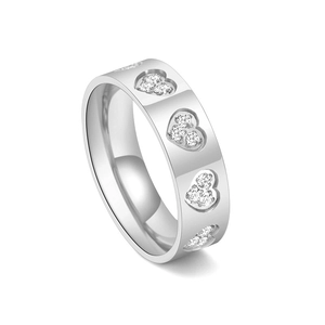 Detailed macro view of silver titanium steel rings with diamond-set heart pattern engraving