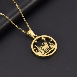 Close-up of golden stainless steel hollow circular pendant with reindeer and trees