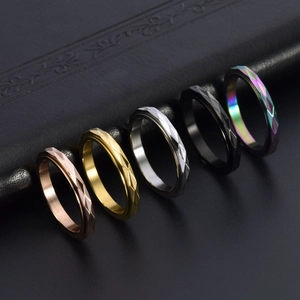 Diamond-cut stainless steel spinner rings in five colors on a dark leather background