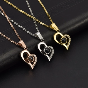 Macro shot of three heart projection necklaces in rose gold, silver, and gold finish