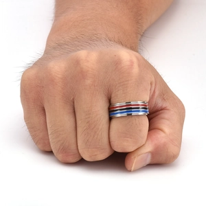 Close-up of a rotating rainbow stainless steel stress relief ring on a hand