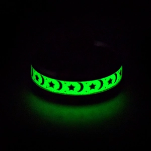 Glow in the dark titanium steel ring featuring green luminous stars and moon patterns