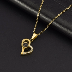 Macro shot of gold heart necklace pendant with inlaid zirconia and projection stone