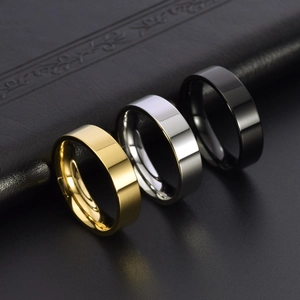 Polished stainless steel band rings in gold, silver, and black on leather texture