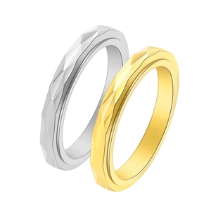 Macro detail of diamond-cut geometric facets on 3mm gold and silver rotating steel rings
