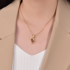 Golden heart projection necklace with micro-pave zircons worn on female neck