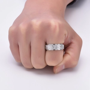 Close-up of a silver rotating ring featuring embossed Ancient Egyptian symbols and motifs