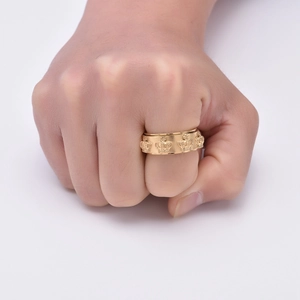 Detail of vintage gold stainless steel crown spinner ring worn on finger for men