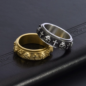 Macro shot of gold and silver spinner rings with gothic skull and cross relief detail