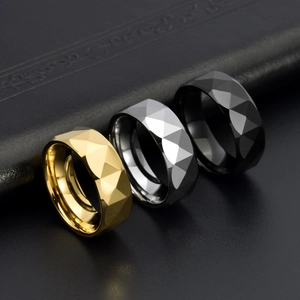 Close-up of geometric faceted rings in gold, silver and black with polished finish