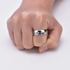 Close-up of a men's tungsten ring featuring a faceted geometric cut in silver finish