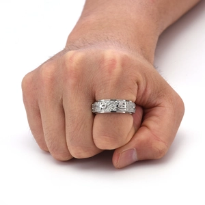 Detail of Ankh symbol and embossed texture on a spinning titanium steel ring for men
