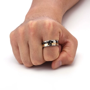 Detail view of men's stainless steel spinner ring with golden and black Roman numeral bands