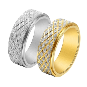 Macro view of rotating spinner rings with gold and silver diamond pattern and sandblasted finish