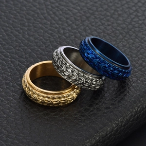 Macro detail of three spinning dragon scale rings in gold, silver, and blue finishes