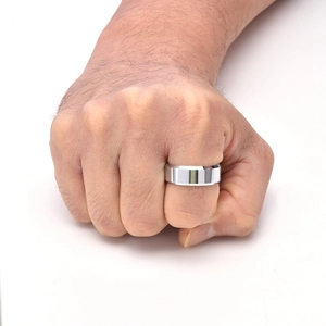 Gros plan d'une large bague en tungstène argent poli avec double bords biseautés au doigt