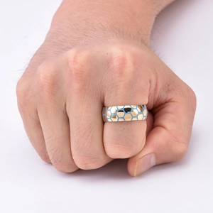 Macro detail of men's golden football ring with light blue hexagonal honeycomb pattern