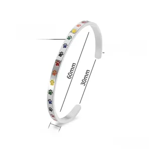 Vue détaillée du bracelet jonc en acier titane argenté avec empreintes de pattes colorées