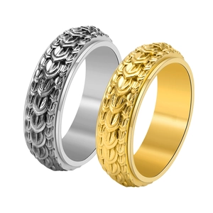 Detailed view of silver and gold spinning rings with textured dragon scale patterns