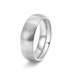 Vue détaillée de la texture ondulée argentée et polie sur une bague en acier
