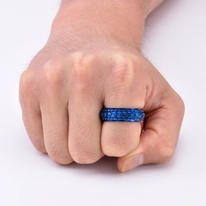 Close-up of blue dragon scale rotatable ring on man's fist showing vintage steel texture