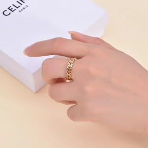 Detailed close-up of 18K gold coin pattern ring worn on finger with elegant lighting
