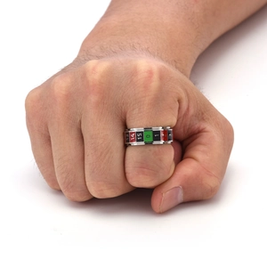 Detail of a rotating roulette ring with red black and green numbers on a male fist