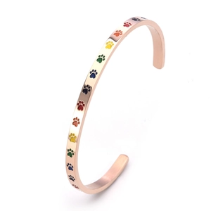 Détail d'un bracelet en acier or rose en forme de C avec empreintes de pattes colorées