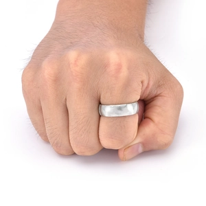 Détail de la bague large en acier inoxydable avec texture ondulée sur main d'homme