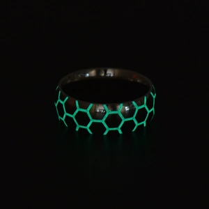 Close-up of luminous football pattern ring with glowing green hexagonal honeycomb texture