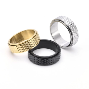 Close-up of rotatable titanium steel rings with diamond-cut texture in gold, silver, and black