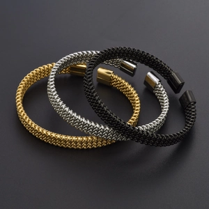 Detailed view of woven mesh open bangles in gold, silver, and black polished steel