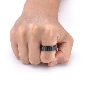 Detail of men's black rotatable titanium steel ring with textured rhombus pattern