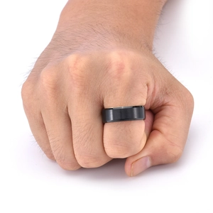 Primo piano di un anello da uomo in acciaio al titanio nero opaco con bordi smussati