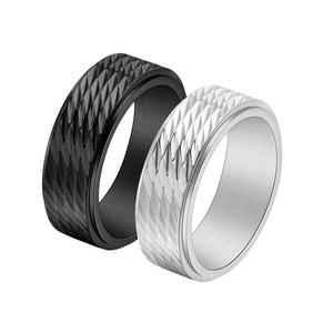 Macro detail of rotating fidget rings with diamond patterns in matte black and silver