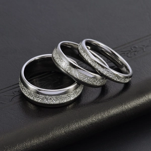 Trois bagues en acier tungstène avec texture mate argentée et bords polis sur cuir noir