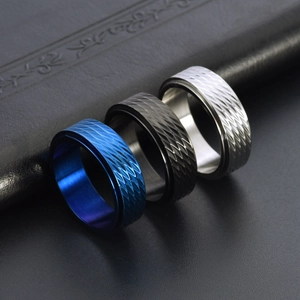 Three rotatable stainless steel stress rings in blue, black, and silver with rhombus patterns