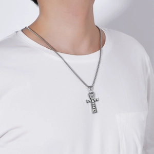 Detail of vintage silver Ankh cross pendant with hieroglyphs on a stainless steel chain