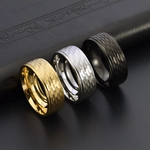 Close-up of hammered titanium steel rings in gold, silver, and black for men
