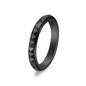 Macro view of black rotatable ring with geometric pyramid studs and brushed interior