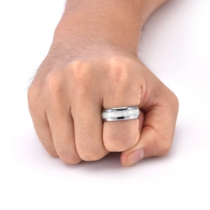 Détail d'une bague en tungstène argenté avec centre texturé mat et bords polis sur la main