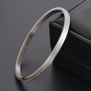 Bracelet jonc en acier titane or rose 18K sablé avec fermoir sur boîte à bijoux noire