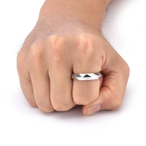 Macro shot of a men's titanium steel ring with geometric diamond-cut facets on a hand