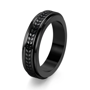 Detailed close-up of a black stainless steel spinner ring with a textured tire tread pattern